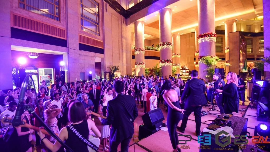 Entertainment at a corporate event with a live band on stage and a crowd of people watching.