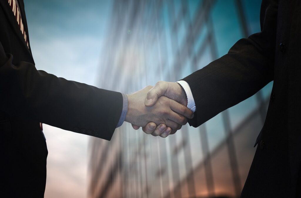 Symbolic image of business relationship between event organiser and event sponsor. Businessmen shaking hands.