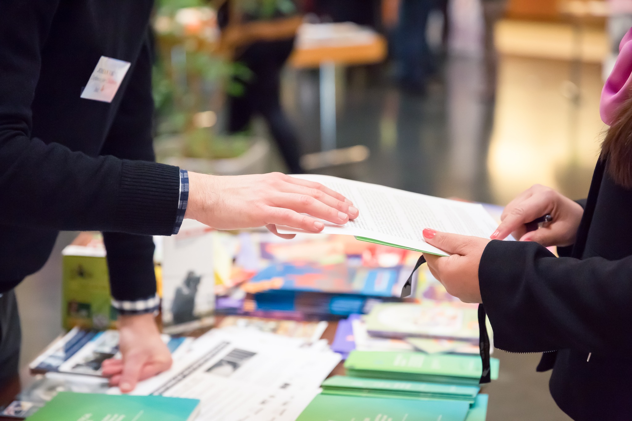 Man and Woman Sharing Information Leaflet over Exhibition Stand