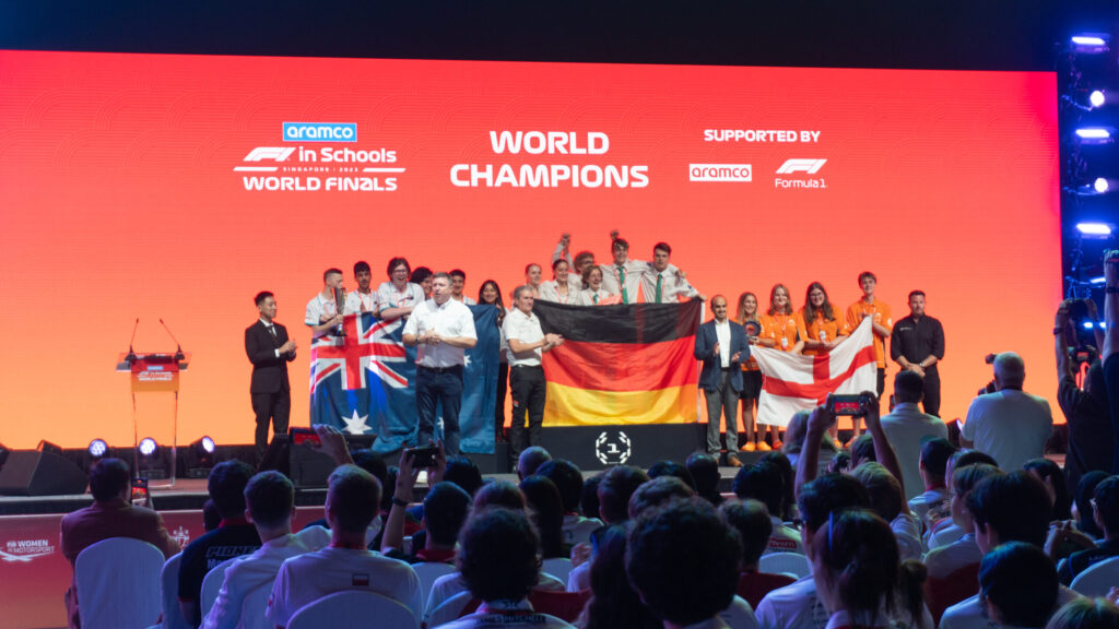 Winning teams at an F1 event celebrate their victory.