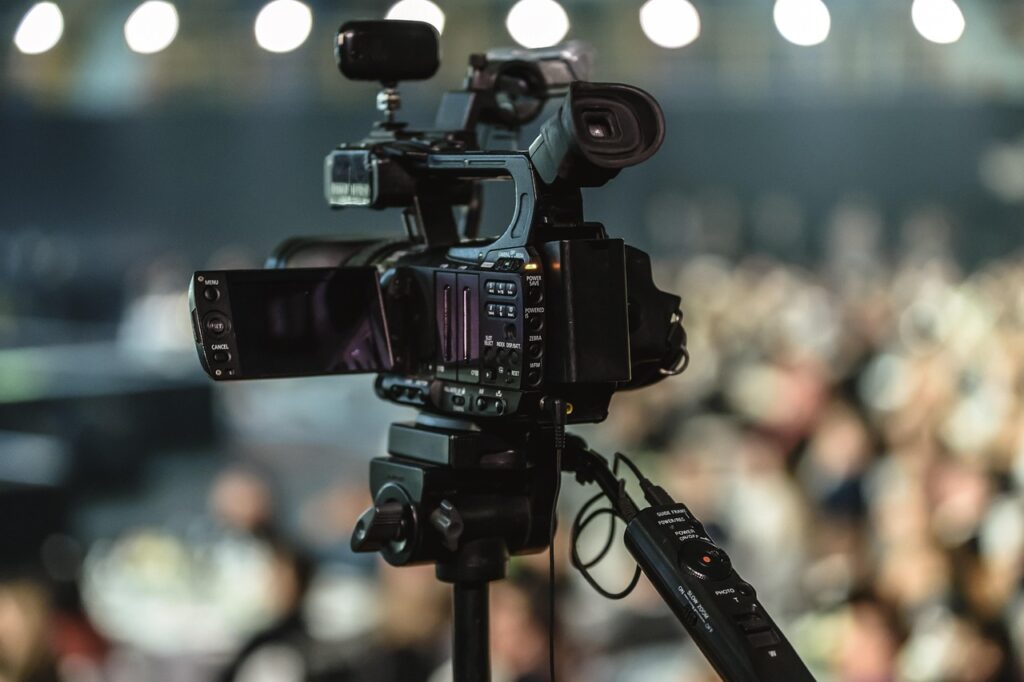 A camera on a tripod recording a seminar or corporate event for post event content creation and audience engagement.