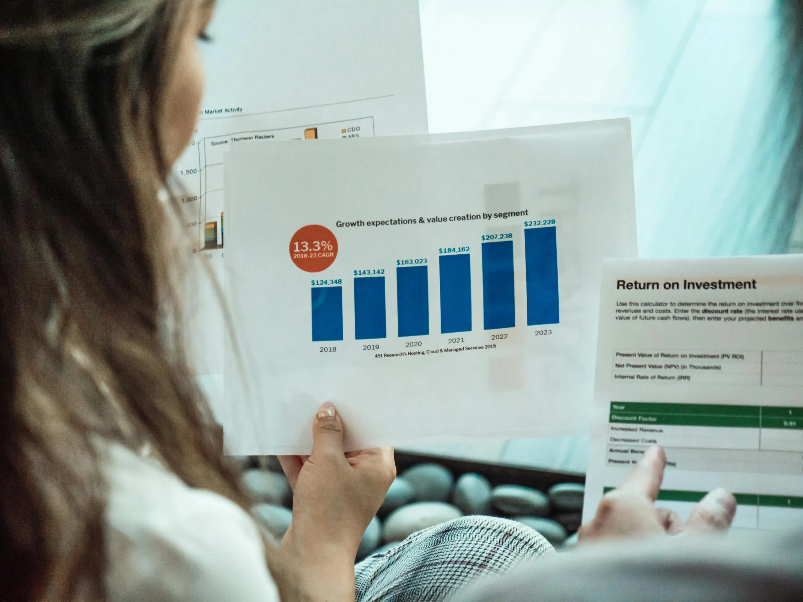 Individual reviewing printed reports, illustrating data-driven ROI evaluation in corporate event planning.