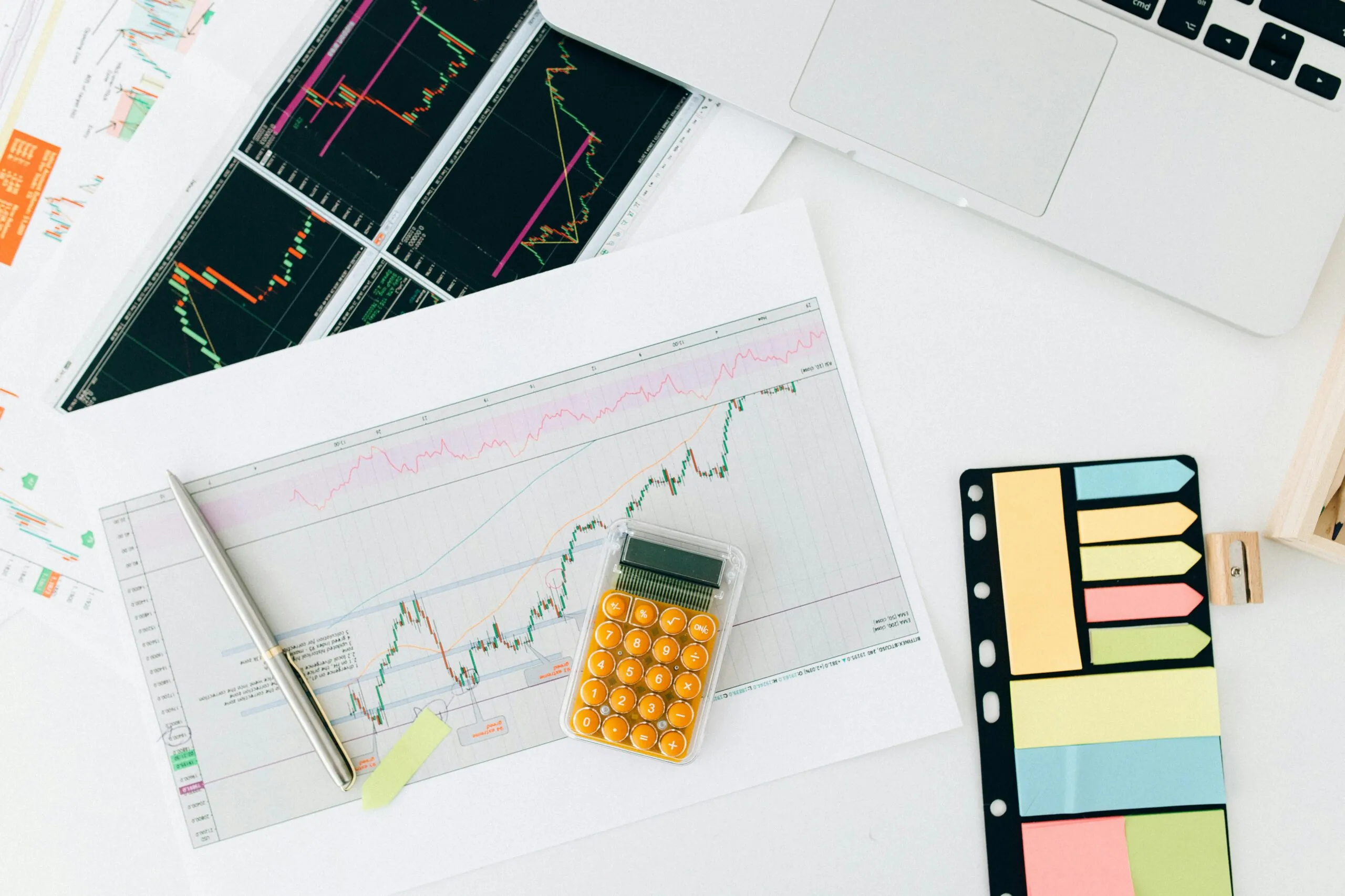 Calculator on top of printed reports, representing predictive event planning through numerical data analysis.