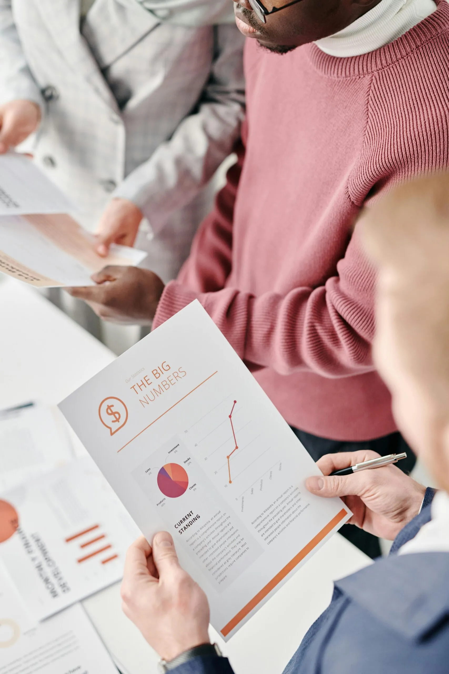Hand holding a printed report with charts, representing data analysis in post-event reporting.