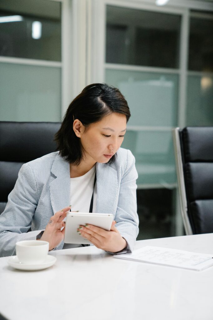A woman is focused on a tablet at a networking event conference table.