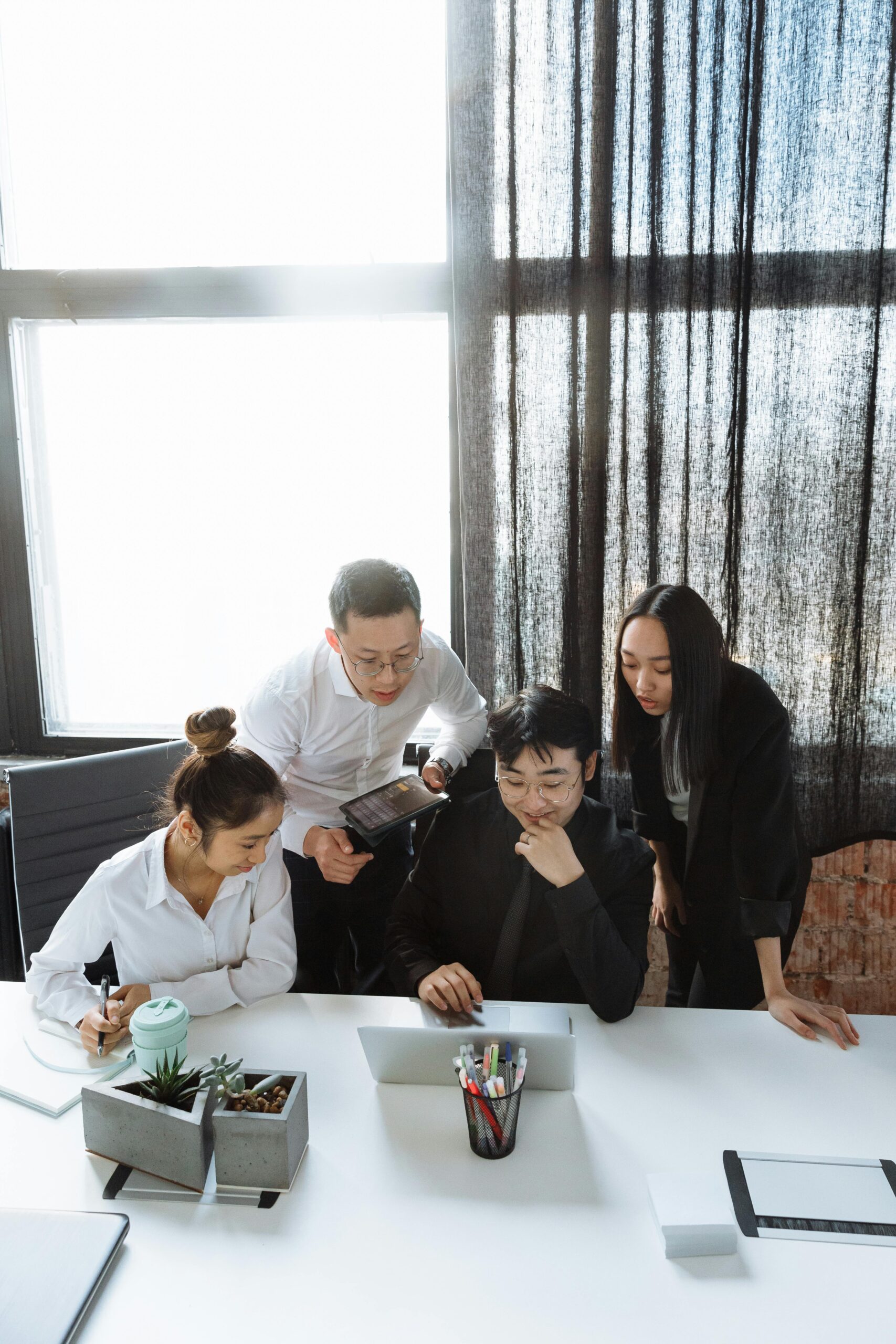 A corporate event planning team collaborates around a laptop.