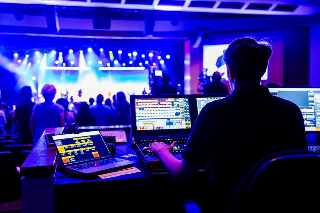 Event production technician managing lighting and livestream technology during a hybrid corporate event in Singapore.